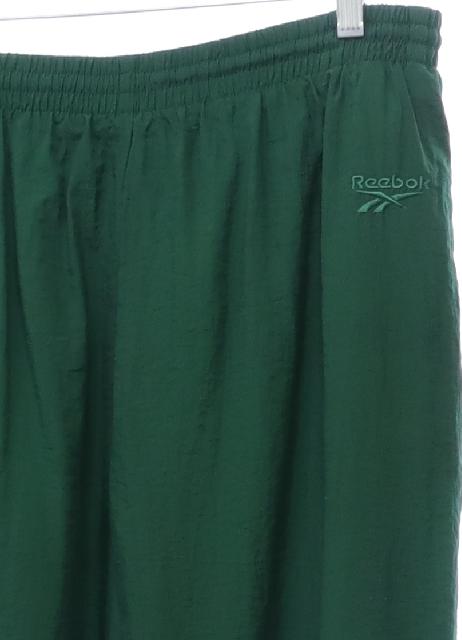 Pants: 90s -Reebok- Mens dark green solid colored crinkle nylon shell flat  front track pants. Elastic cuff hem with ankle zipper, vertical seam inset  side entry front pockets with brand logo on